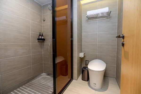 A modern bathroom with a glass-enclosed shower, a toilet, and a sink. - Ji Hotel (Chongqing)