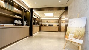A modern kitchen with a central island, built-in appliances, and a large painting on the wall. - Ji Hotel (Chongqing)
