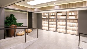 A modern interior with a staircase, a potted plant, and illuminated shelves. - Ji Hotel (Chongqing)