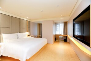 A modern hotel room with a large bed, a desk, and a large window. - Ji Hotel (Chongqing)