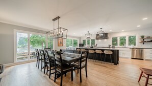 Una cocina moderna con comedor, ventanas amplias y vistas a zonas verdes.