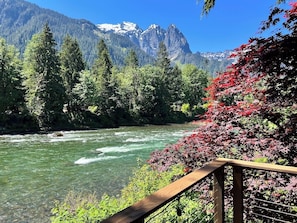 A river with clear water, surrounded by dense green trees and a wooden railing. - Mountain View Cabin w/ amazing mountain views, hot tub, wifi, wood stove (Gold Bar)