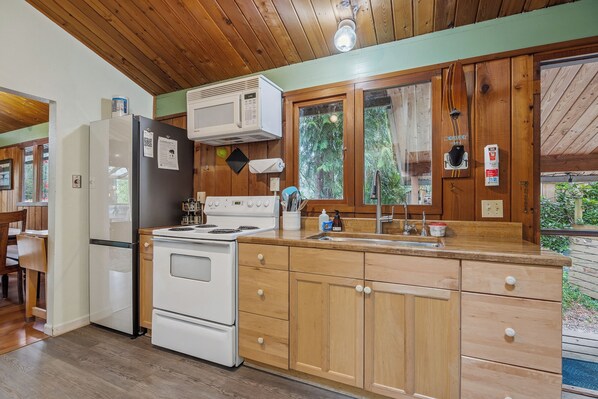 A kitchen with wooden cabinets, a white refrigerator, a stove, and a microwave. - Mountain View Cabin w/ amazing mountain views, hot tub, wifi, wood stove (Gold Bar)