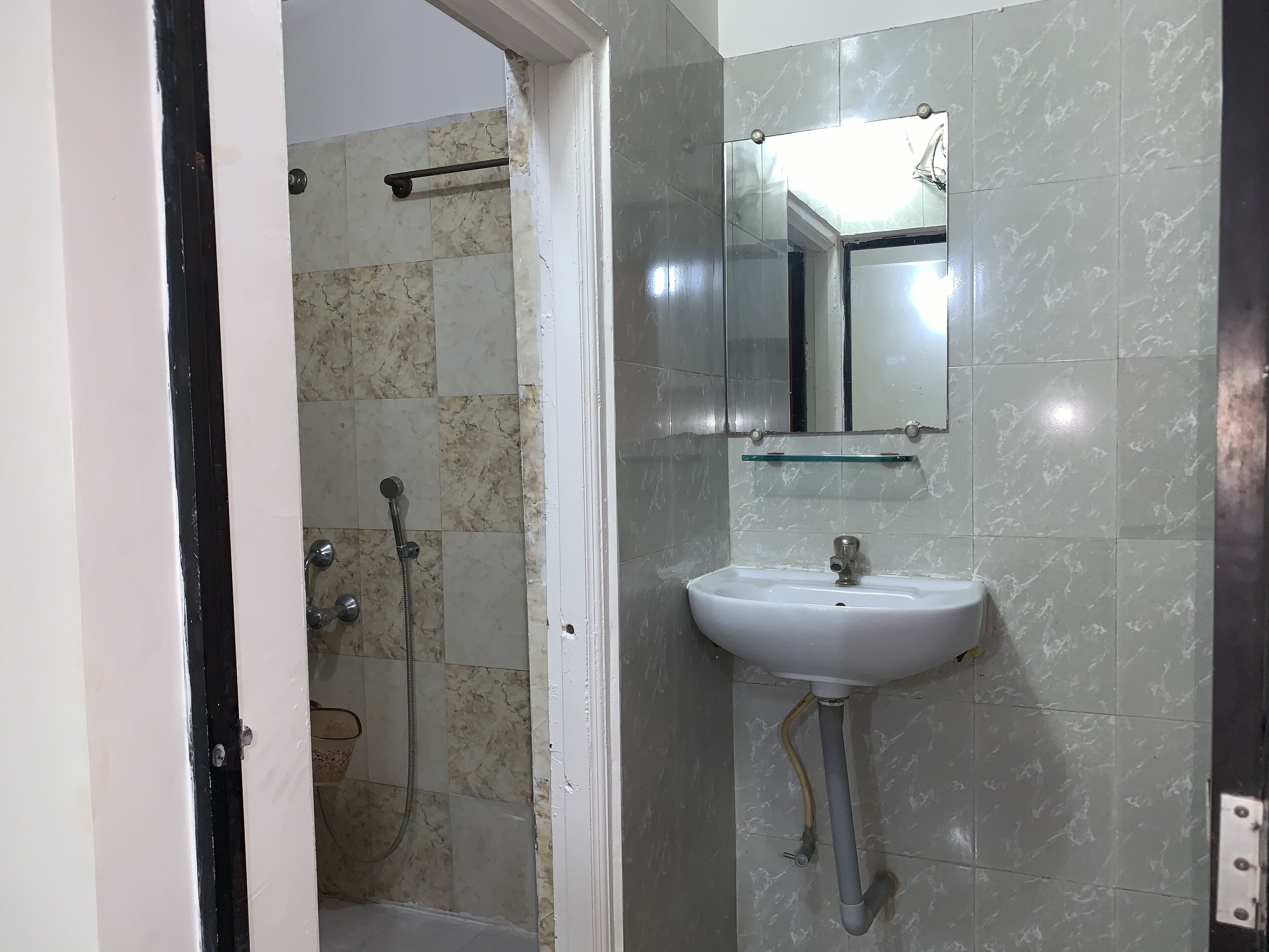 Un baño con ducha, lavabo y espejo.