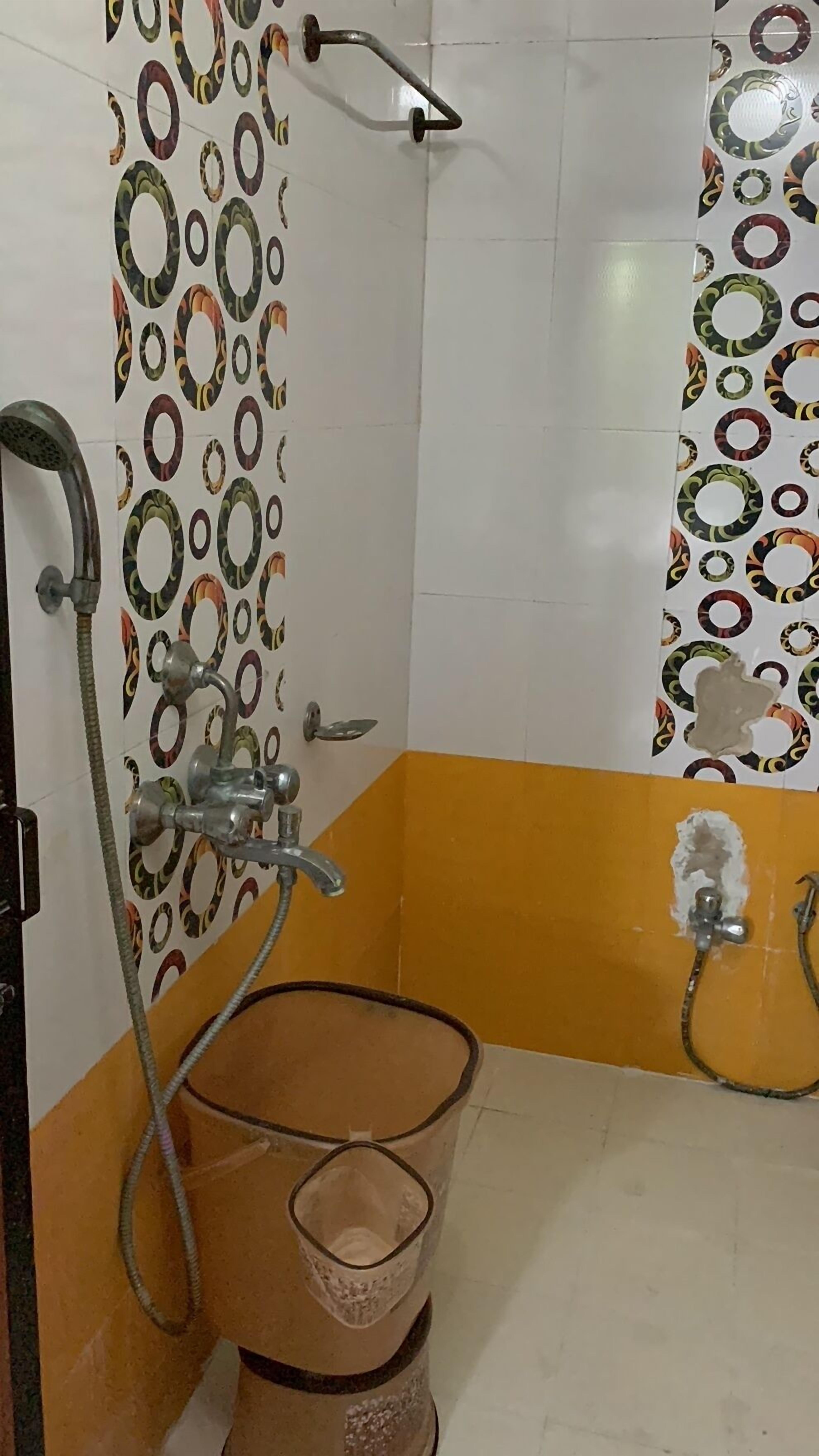 A bathroom with a shower, a bathtub, and a toilet. The walls are tiled with a circular pattern.