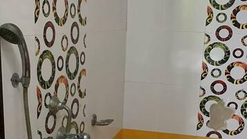 A bathroom with a shower, a bathtub, and a toilet. The walls are tiled with a circular pattern.
