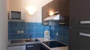 A compact kitchen with a dishwasher, a coffee maker, and a microwave on the countertop. - "La Fautaise" house in residence with swimming pool, near beach. (La Faute-sur-Mer)