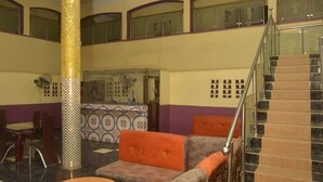A lobby with a staircase, seating area, and decorative wall tiles.
