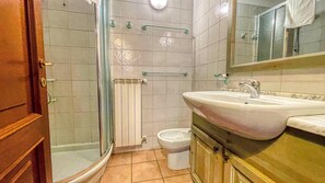 A bathroom with a shower, toilet, and sink.