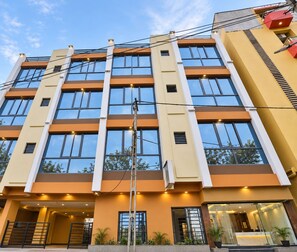 A multi-story hotel with a modern facade, large windows, and a visible entrance with a staircase.