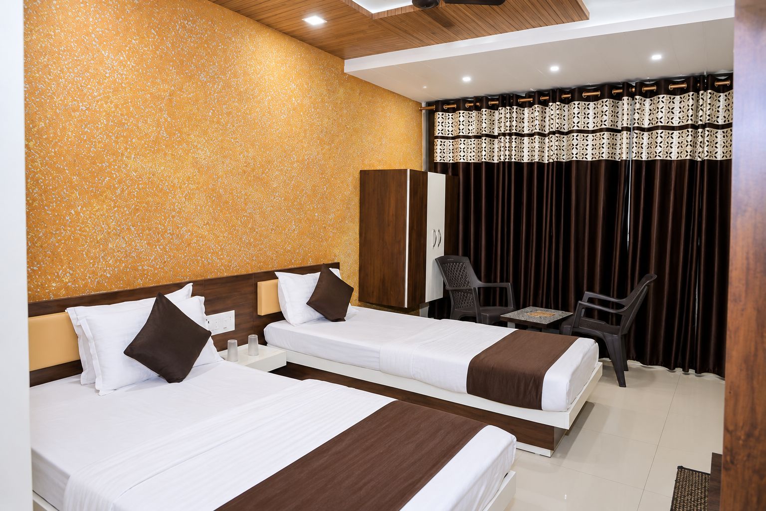 Une chambre d’hôtel avec deux lits, un bureau et une chaise.