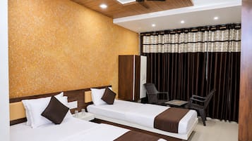 Une chambre d’hôtel avec deux lits, un bureau et une chaise.