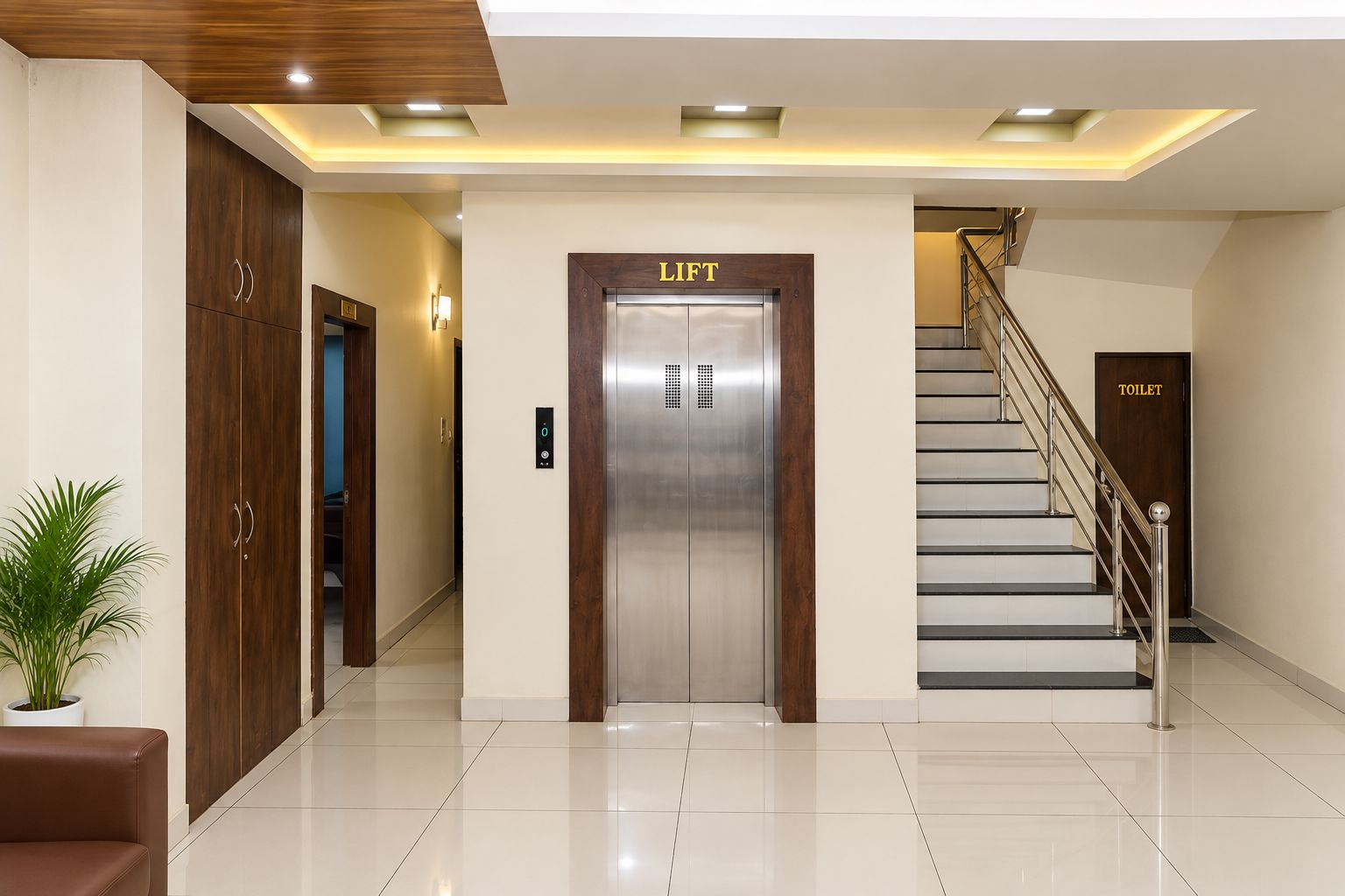 Een hotel lobby met een lift, een trap en een toilet.