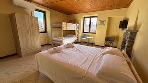 Une chambre avec un lit superposé, un bureau, une chaise et une armoire.