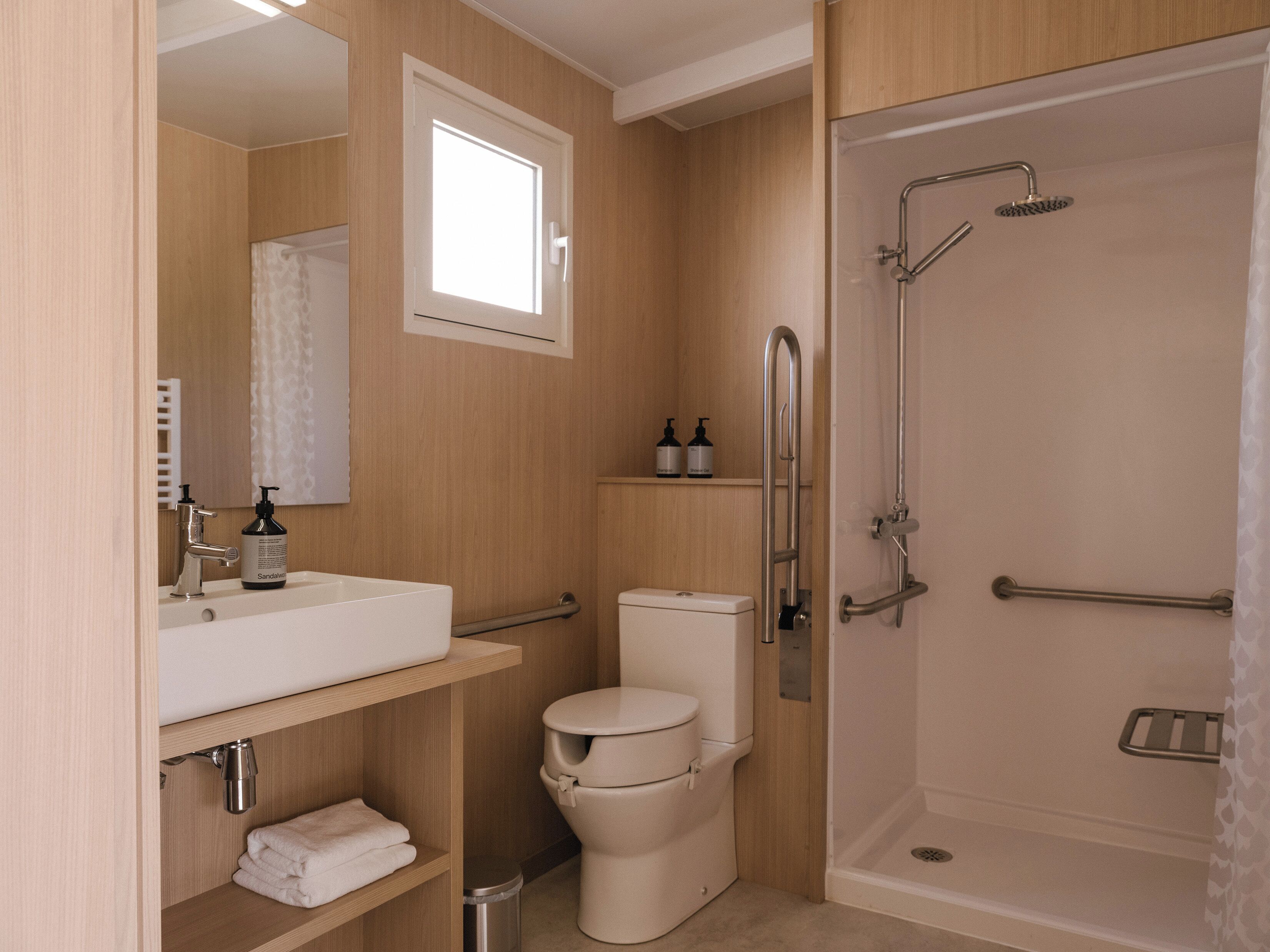 A modern bathroom with a toilet, sink, and shower.