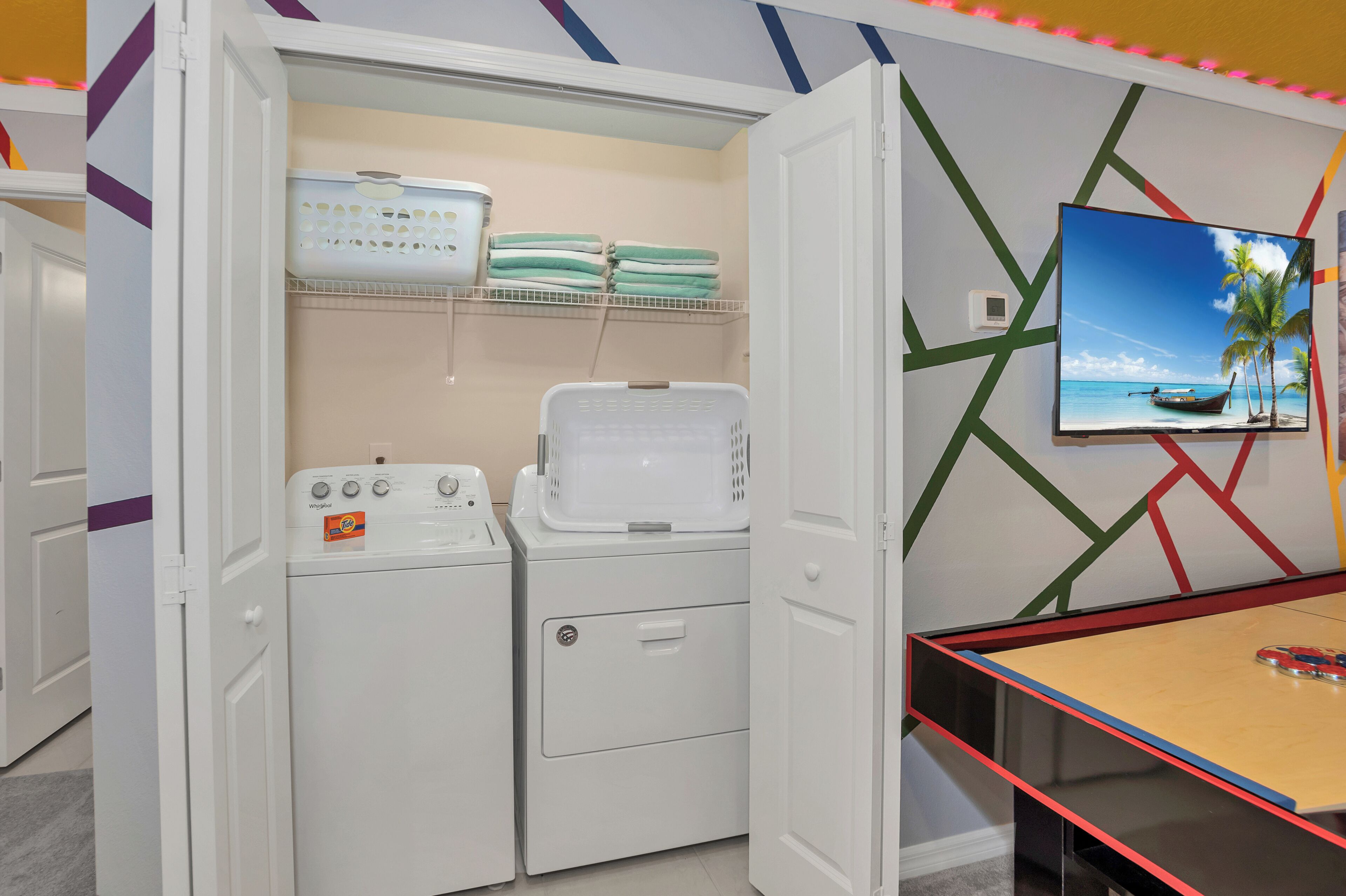 A laundry room with a washing machine, dryer, and stacked laundry baskets.