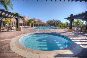 A swimming pool with a tiled deck, lounge chairs, and a covered area with umbrellas. - 4024 Breakview Drive #208 (Orlando)