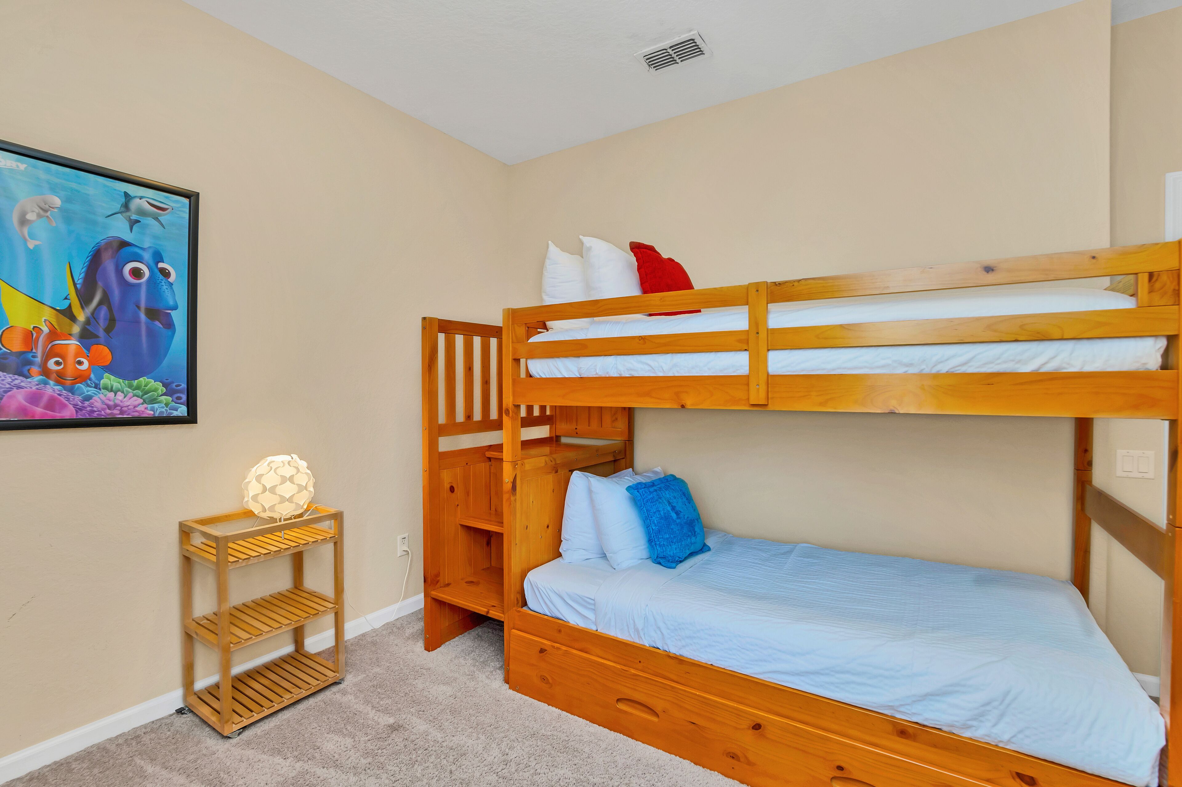 Habitación con literas, una estantería y un cuadro en la pared.