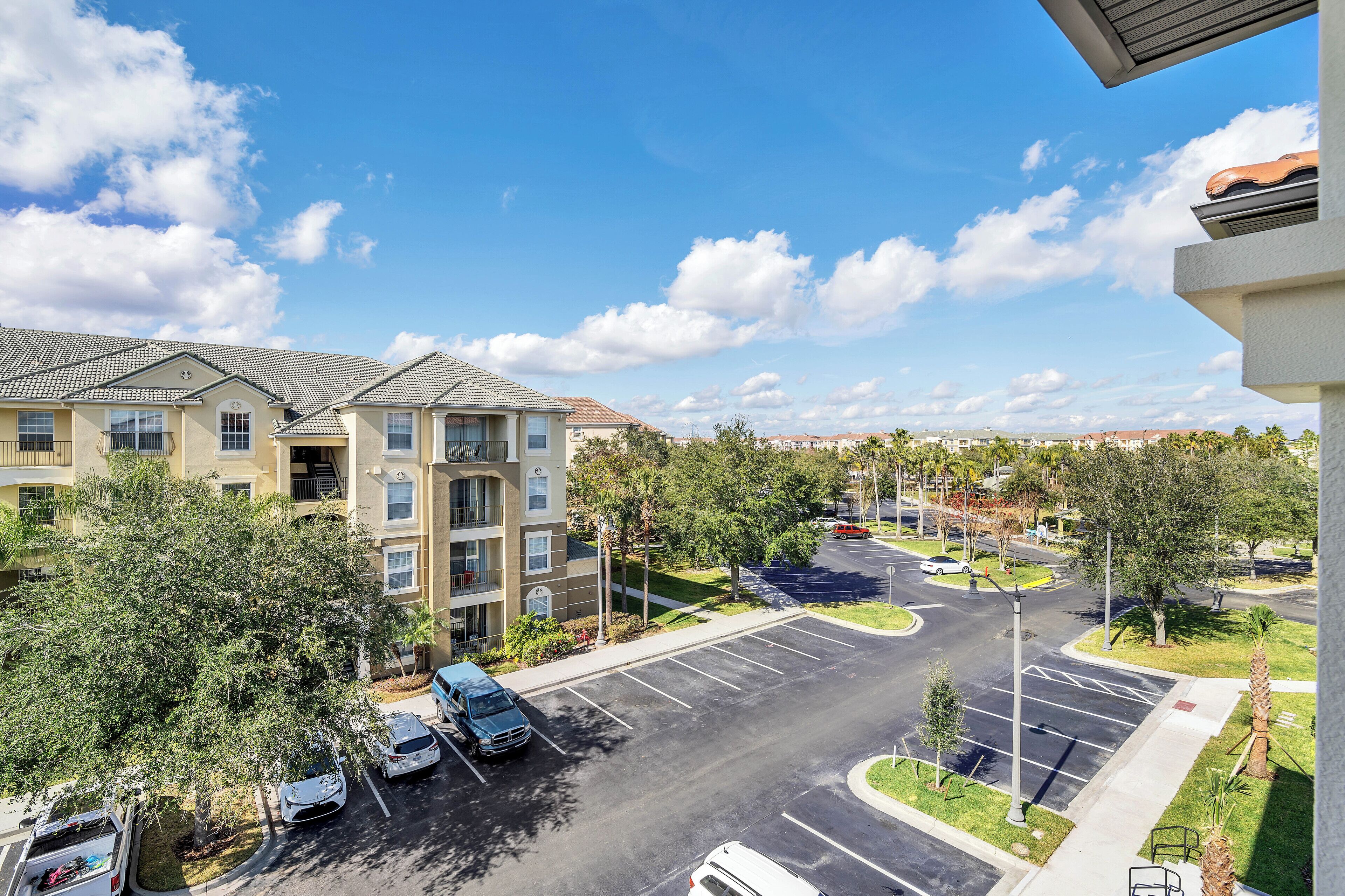 A multi-story residential building with a parking lot in front.