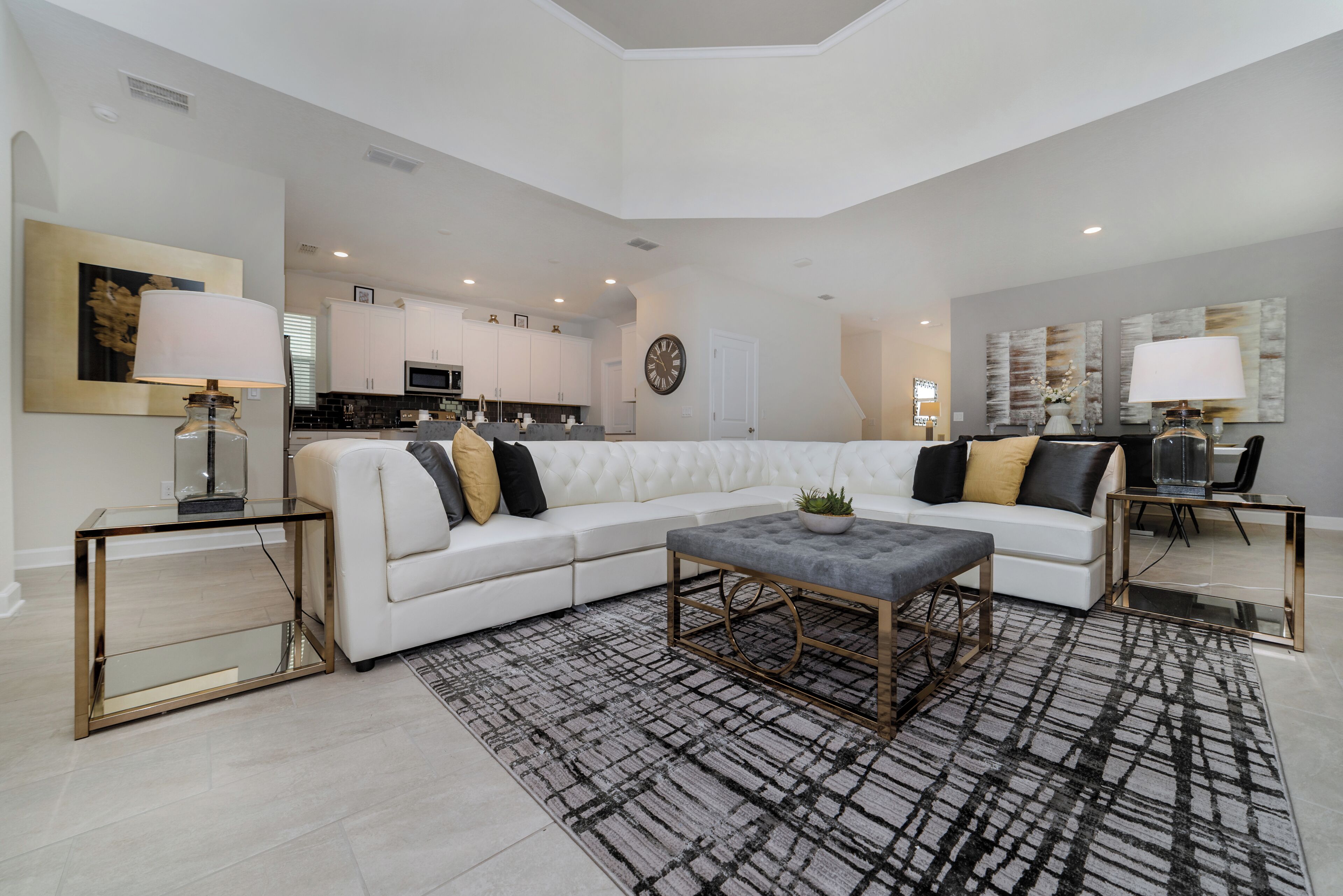 A modern living room with a sectional sofa, a coffee table, and a rug.