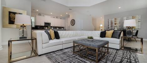 A modern living room with a sectional sofa, a coffee table, and a rug.