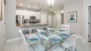 A modern kitchen with white cabinets, stainless steel appliances, and a central island. - Luxurious Condo Near Disneyfree Waterpark Access (Kissimmee)