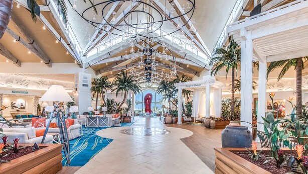 A spacious atrium with high ceilings, modern chandeliers, and a central red sculpture. - Large Margaritaville Villa w/ Private Pool + View (Kissimmee)
