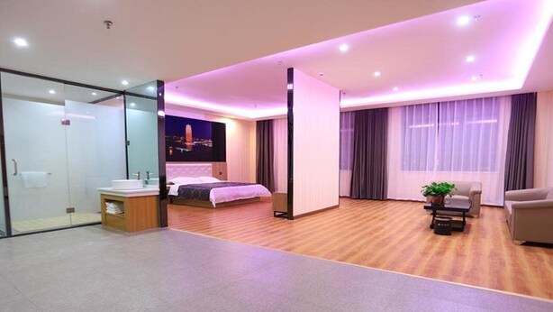A modern hotel room with a bed, bedside table, and a desk area. - Chonpines Hotel (Zhengzhou)