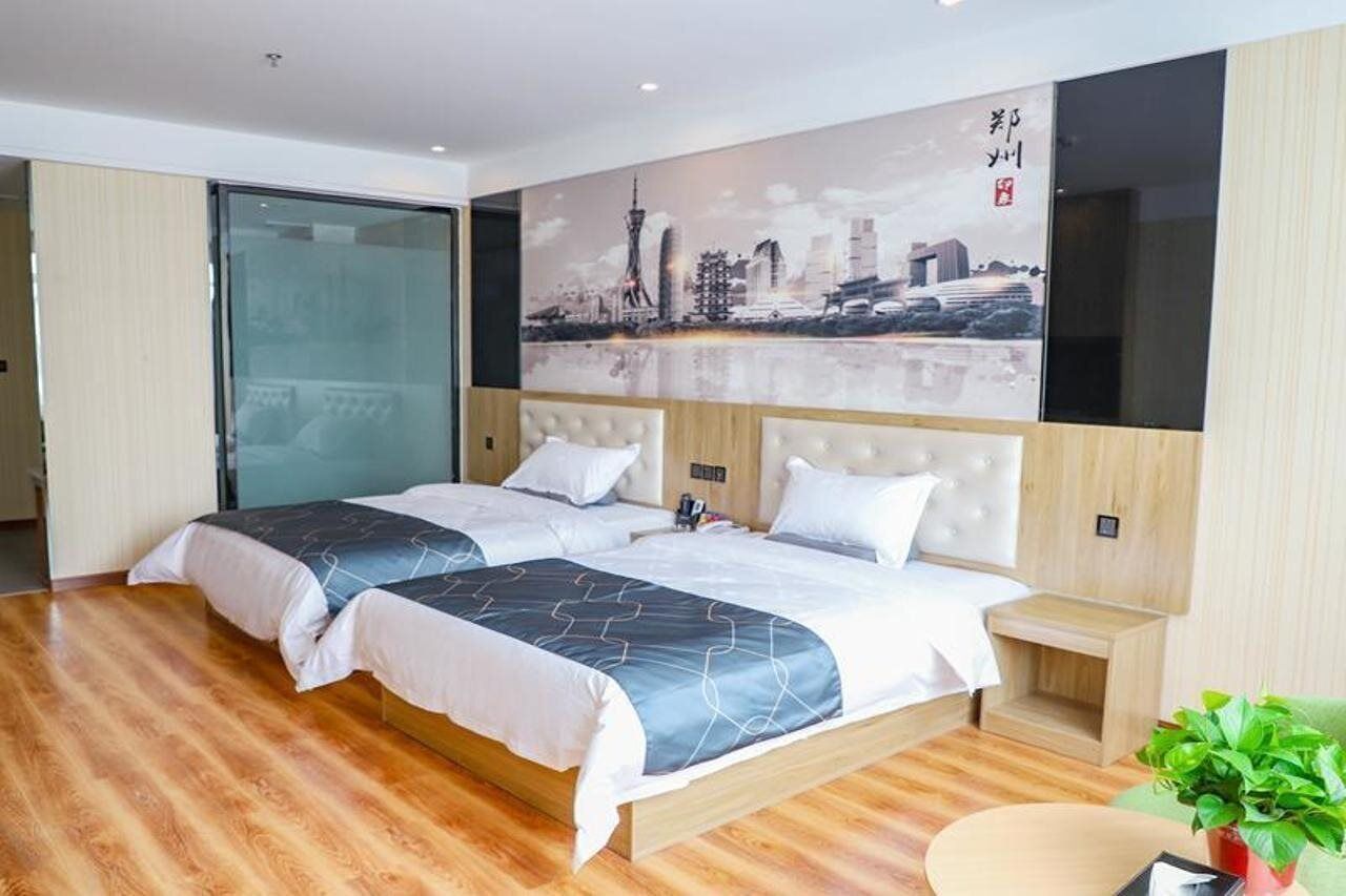 A modern hotel room with a large bed, a cityscape mural on the wall, and a wooden floor.
