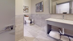 A modern bathroom with a toilet, sink, and towel rack.