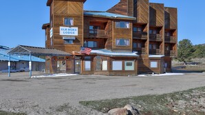 Un chalet en bois à plusieurs étages, sur lequel on peut lire l’inscription : « ELK HORN LODGE ».