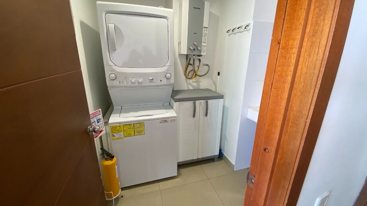 A compact laundry room with a washing machine, a dryer, and a small sink.