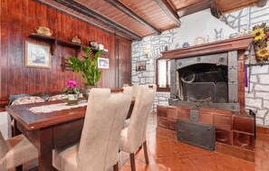 A dining area with a wooden table, chairs, and a fireplace.
