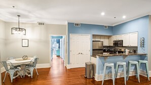 Eine moderne Küche mit weißen Schränken, einem Edelstahlkühlschrank und einer blauen Akzentwand.