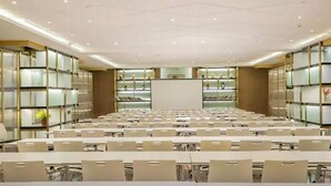A conference room with rows of tables and chairs, a whiteboard, and bookshelves along the walls. - Atour Hotel Qinhuangdao Beidaihe Zhoudun (Qinhuangdao)