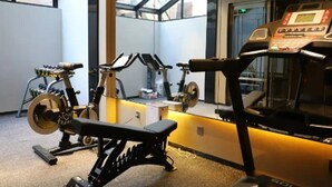 A gym with a treadmill, stationary bikes, and a bench. - Atour Hotel Qinhuangdao Beidaihe Zhoudun (Qinhuangdao)