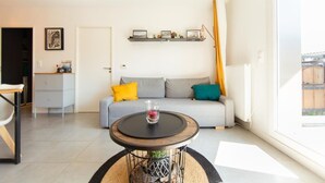 A modern living room with a sofa, a coffee table, and a bookshelf. - Appartment Christine in Lège city for 5 persons (Lège-Cap-Ferret)
