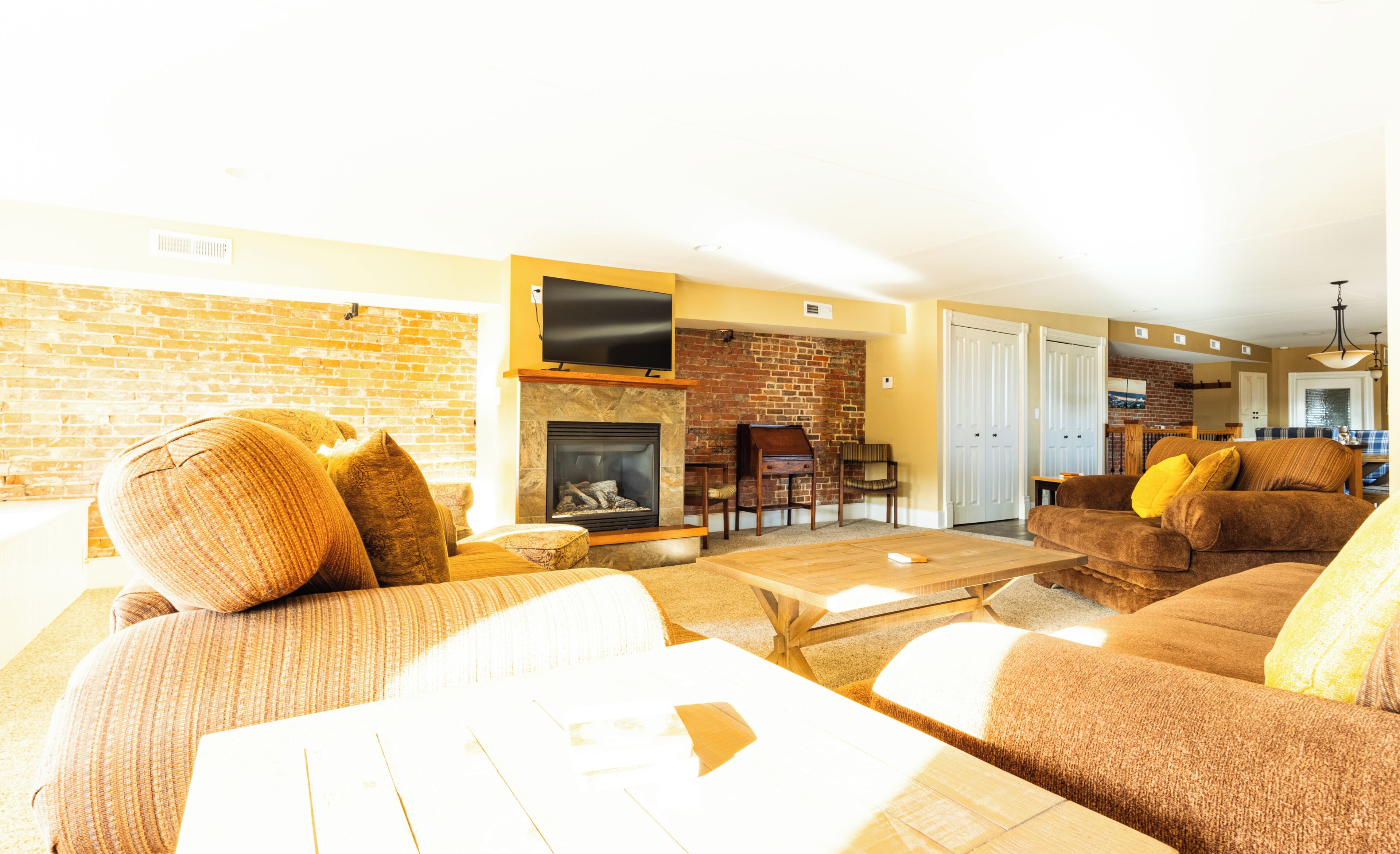 Una sala de estar con chimenea, sofás y televisor.