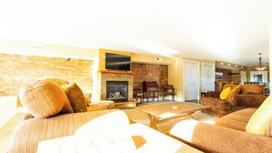A living room with a fireplace, sofas, and a television.