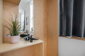 Guest room with a desk, mirror, and window.