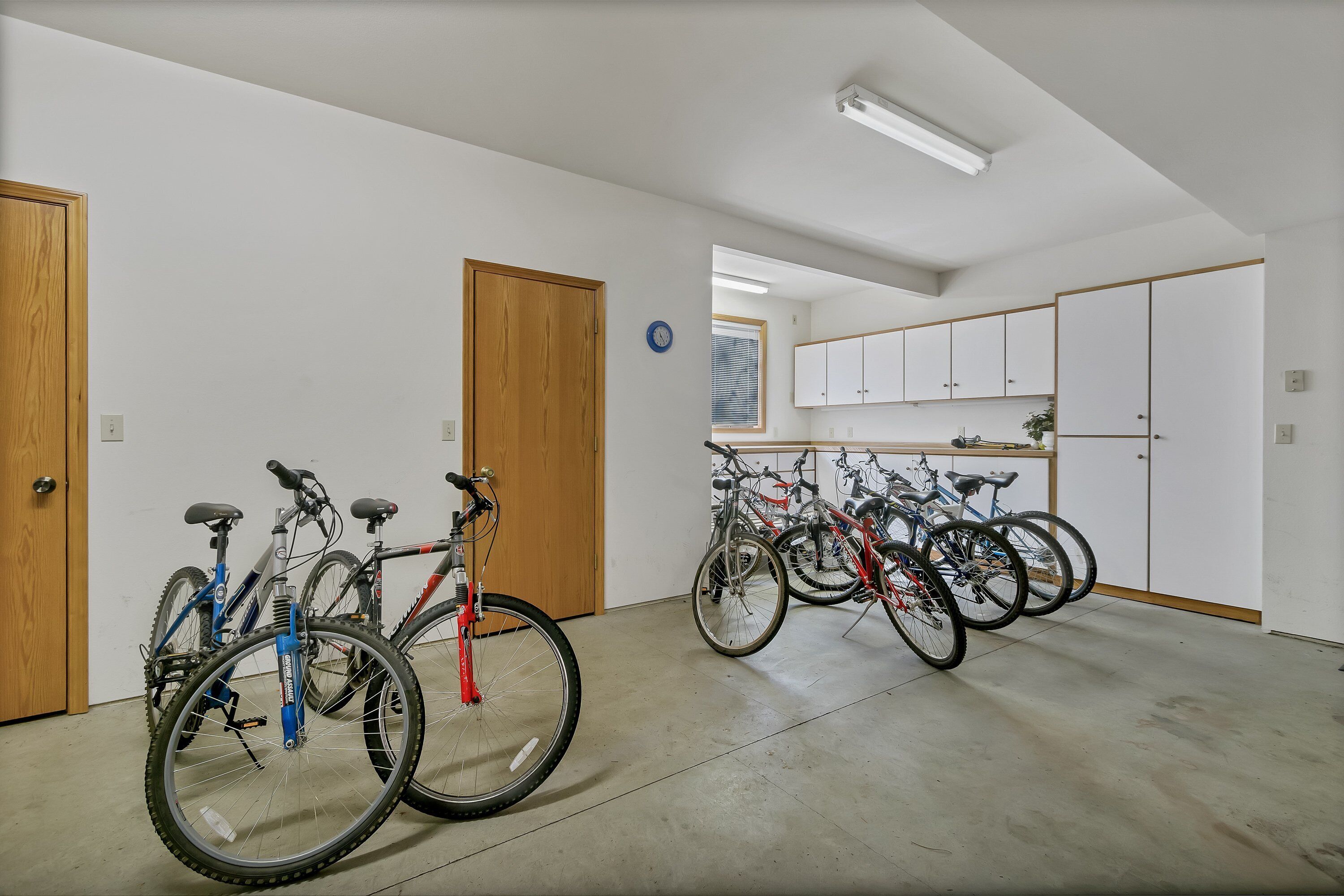 A spacious indoor area with multiple bicycles parked against the walls.