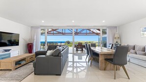 Ein geräumiger Wohnbereich mit Sofa, Fernseher und Esstisch.