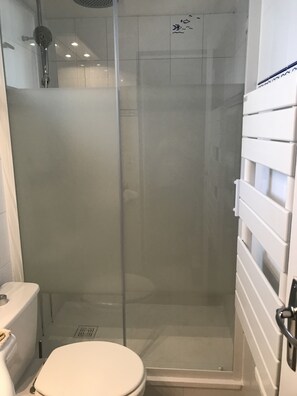 Enjoy a refreshing shower in this modern bathroom with a glass-enclosed shower stall and convenient toilet.