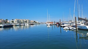 A marina with various boats docked, calm water, and buildings in the background. - Studio port arcachon (Arcachon)