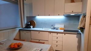 A compact kitchen with a sink, a coffee maker, and a bowl of fruit on the table. - Studio port arcachon (Arcachon)