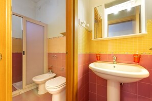 A bathroom with a toilet, bidet, and sink.