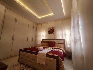 A bedroom with a bed, wardrobe, and a ceiling light fixture. - Nadi Paradise (Abuja)
