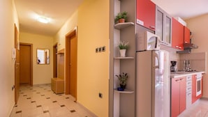 Corridoio di un albergo con angolo cottura, dotato di frigorifero, pensili e lavello.