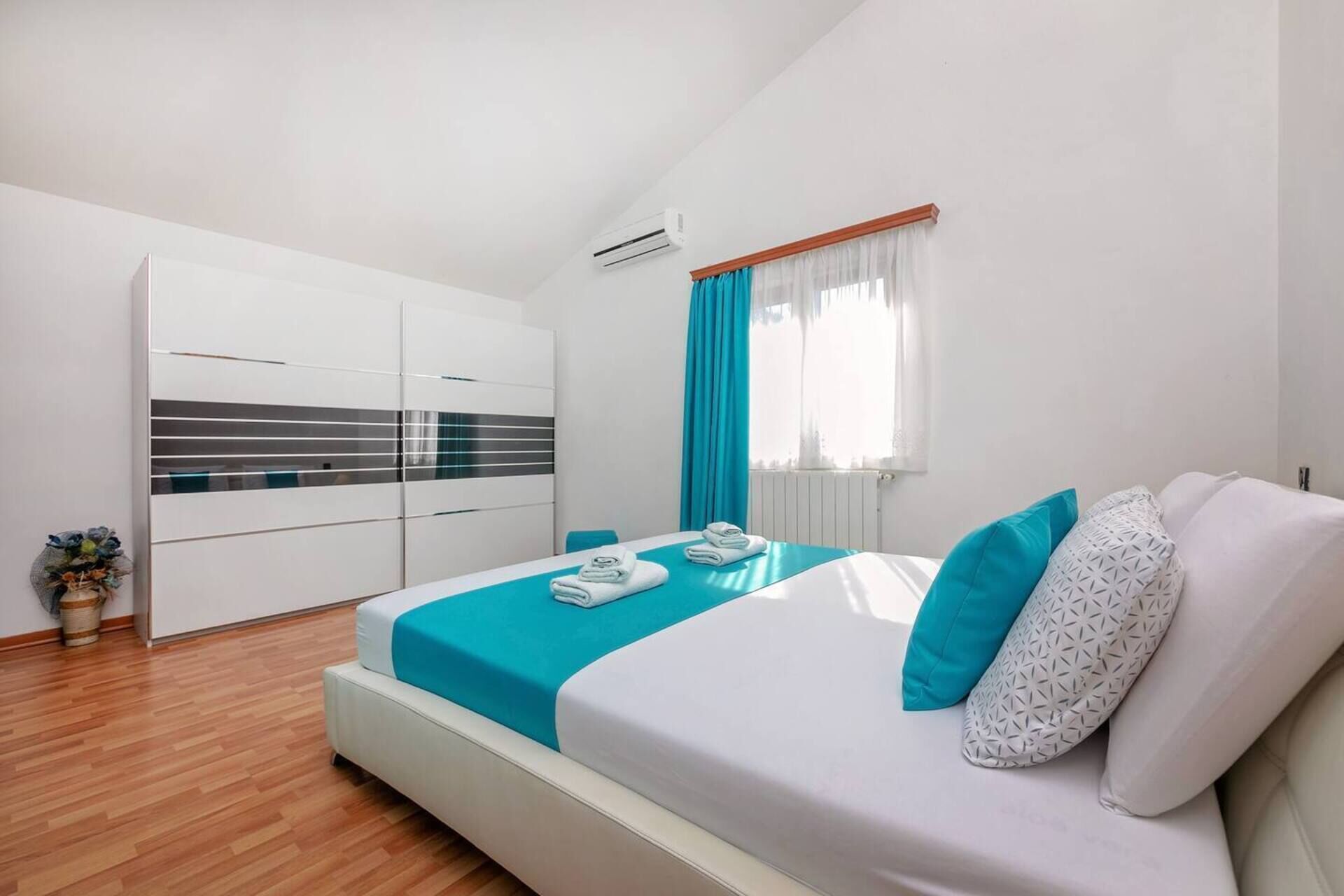 Une chambre moderne avec un lit, une armoire et une fenêtre avec des rideaux.