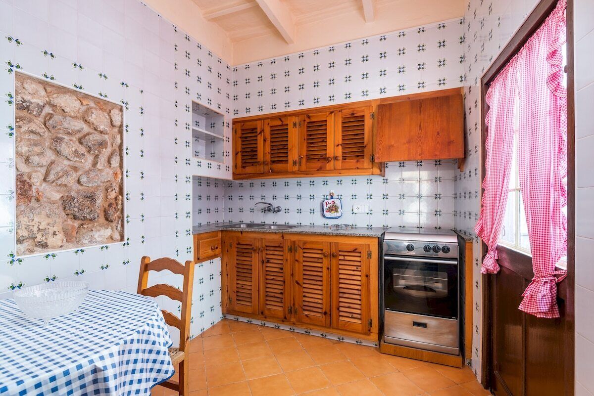 A kitchen with wooden cabinets, a stove, and a tiled backsplash.